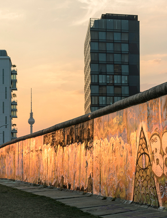 Street‑Art an der Berliner Mauer mit Blick auf den Fernsehturm – urbanes Wahrzeichen der Hauptstadt.
