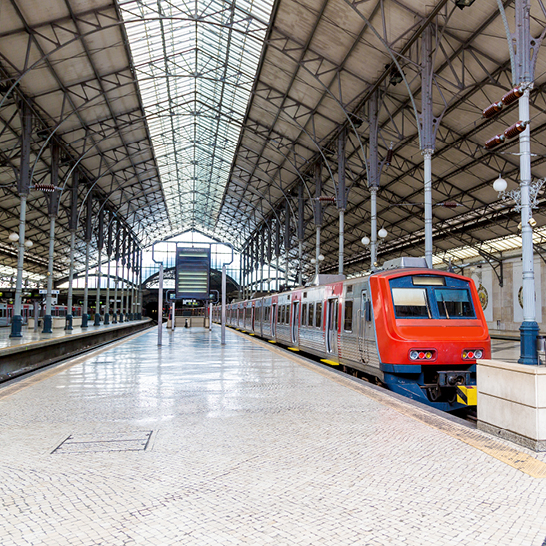 Un train est stationné sous le toit d'une gare à Lisbonne.