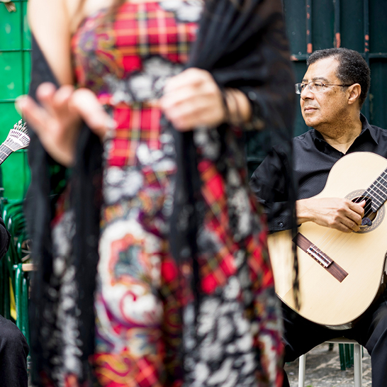 Une musicienne en robe interprète un morceau de Fado à la guitare à Lisbonne.