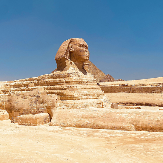 Grosse Sphinx-Statue im Wüstensand von Kairo, majestätisch und beeindruckend in der heißen Sonne.