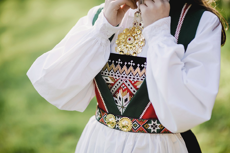 Une femme en tenue traditionnelle pose pour une photo en Norvège.