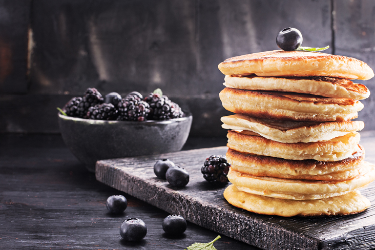 Une pile de pancakes garnie de baies et de feuilles de menthe, servie aux États-Unis.