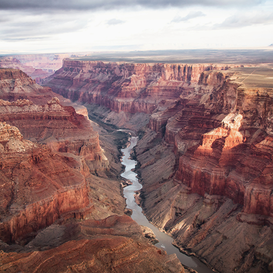 Une rivière serpente à travers le canyon du Grand Canyon, révélant des parois rocheuses impressionnantes.